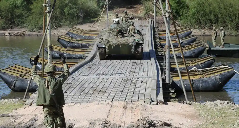 Un soldado guía el pasaje de un blindado sobre un puente M4-T6